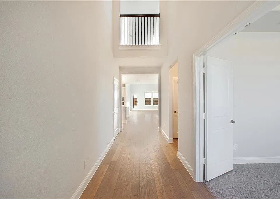 Entry hallway with wood-look floors and open view upstairs